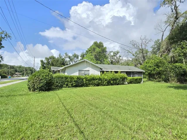 a front view of a house with yard and green space