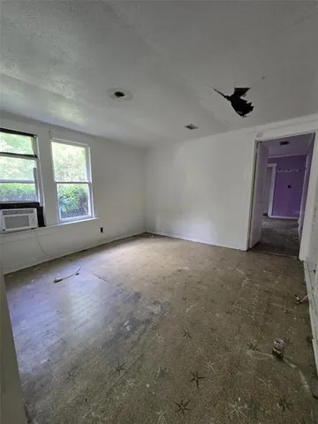 an empty room with windows and cabinet