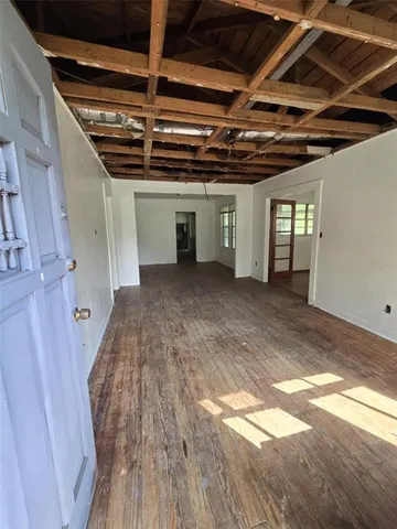 a view of a hallway with wooden floors and stairs