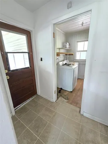 a view of an empty room with wooden floor and a balcony