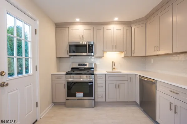 a kitchen with cabinets appliances and a window