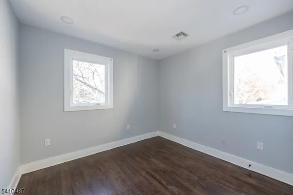 a view of a room with wooden floor and windows in it
