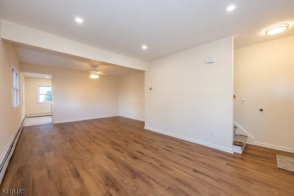 a view of empty room with wooden floor
