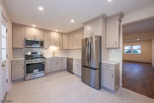 a kitchen with stainless steel appliances granite countertop a refrigerator stove and microwave