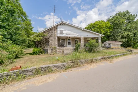 a front view of house with yard and trees around