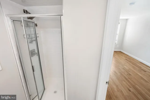 an empty room with wooden floor door and windows