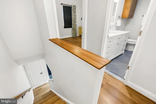 a view of a hallway with wooden floor and staircase