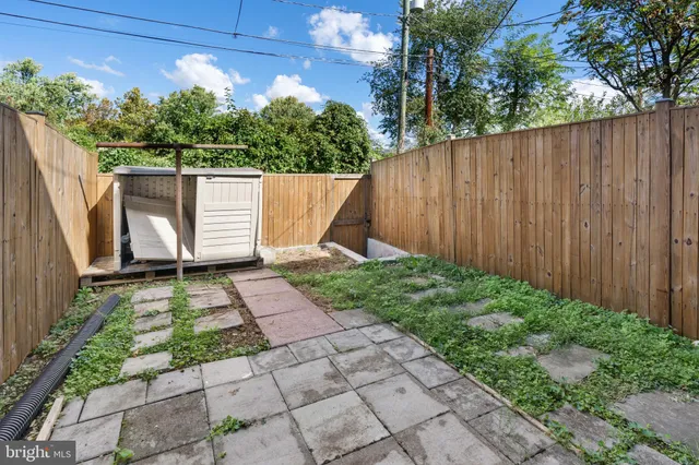 a view of a house with backyard and wooden fence