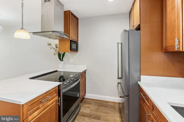 a kitchen with stainless steel appliances granite countertop a sink a stove and a refrigerator