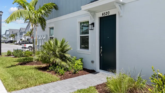 a kitchen with stainless steel appliances granite countertop a refrigerator a sink a stove and white cabinets