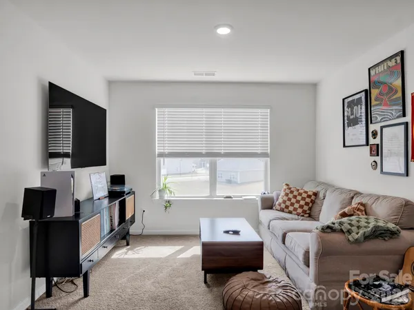 a living room with a couch and a bookshelf with wooden floor