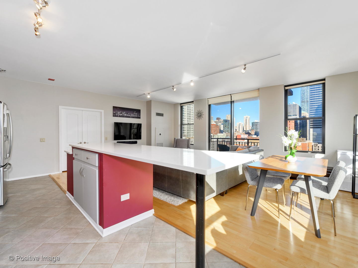 330 North Jefferson Street, Unit 904 Chicago, IL 60661 - Photo 8 of 27 a kitchen with stainless steel appliances kitchen island granite countertop a stove a sink dishwasher and white cabinets with wooden floor