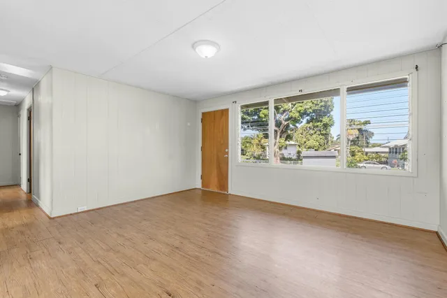 an empty room with wooden floor and a window