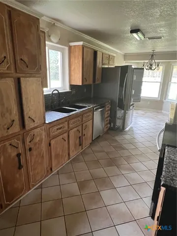 a kitchen with stainless steel appliances a sink stove and cabinets