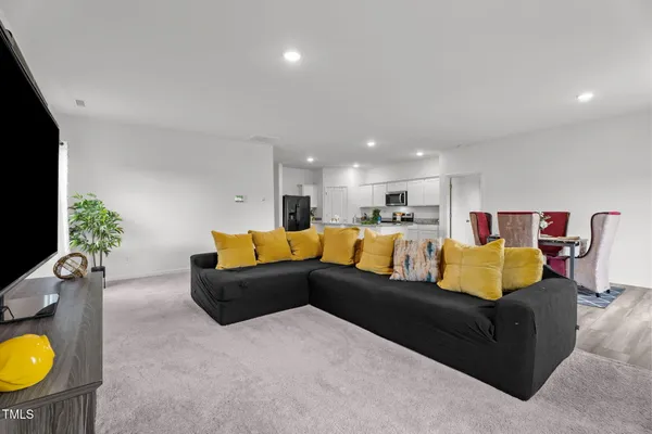a kitchen with granite countertop stainless steel appliances a sink a stove a microwave a refrigerator and cabinets