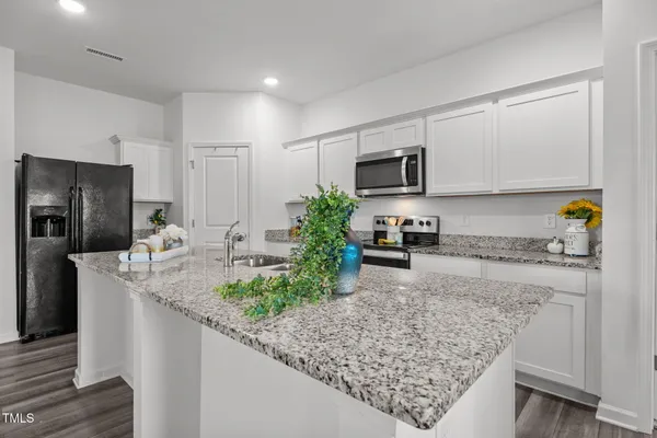a kitchen with sink cabinets and wooden floor
