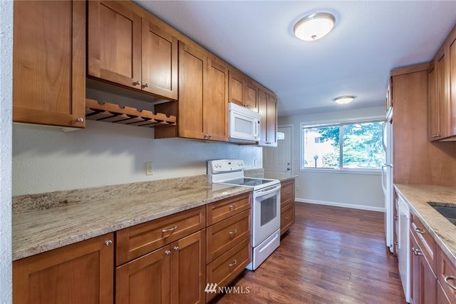 a kitchen with a stove and wooden floor