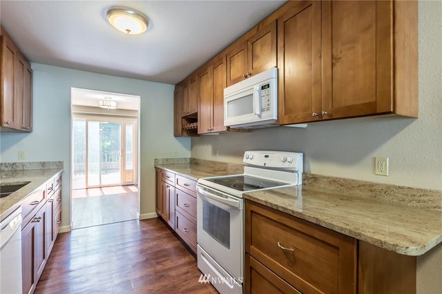 a view of an empty room with wooden floor and closet