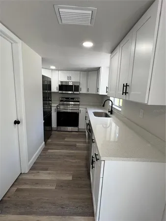 a kitchen with kitchen island stainless steel appliances a refrigerator sink and stove