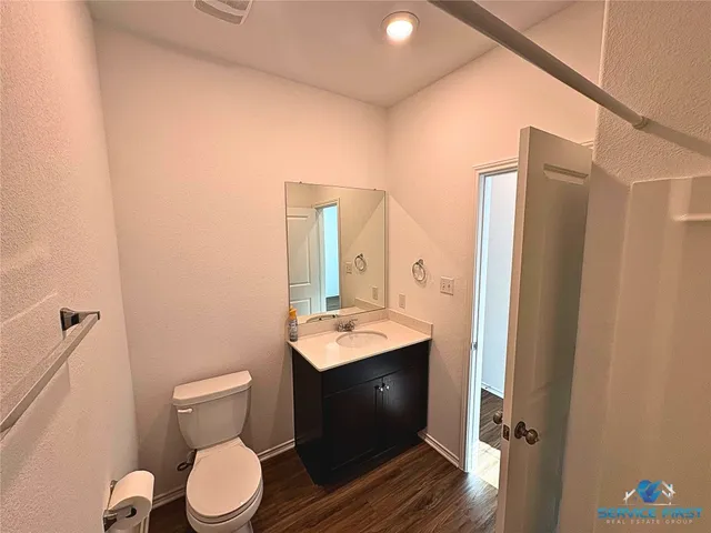 a bathroom with a sink vanity mirror and toilet