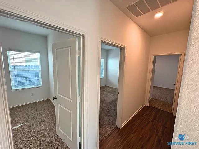 a view of a hallway with wooden floor and closet
