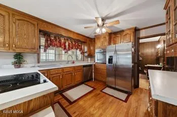 a kitchen with stainless steel appliances granite countertop a sink a stove and a refrigerator