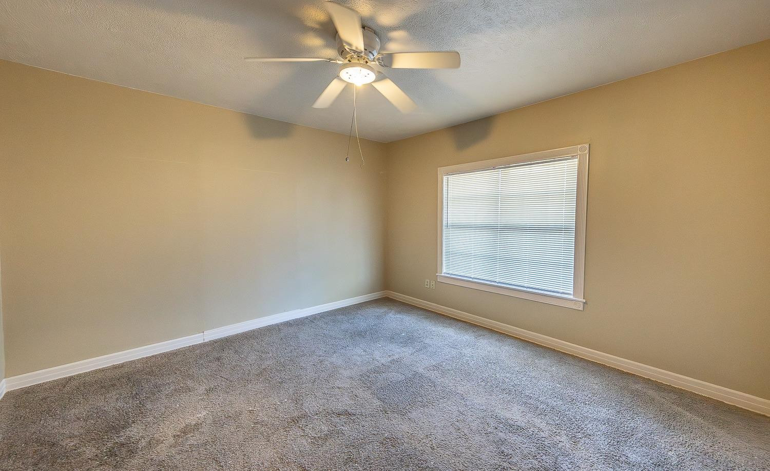 2104 14th Street Lubbock, TX 79401 - Photo 11 of 17 an empty room with a window and a ceiling fan
