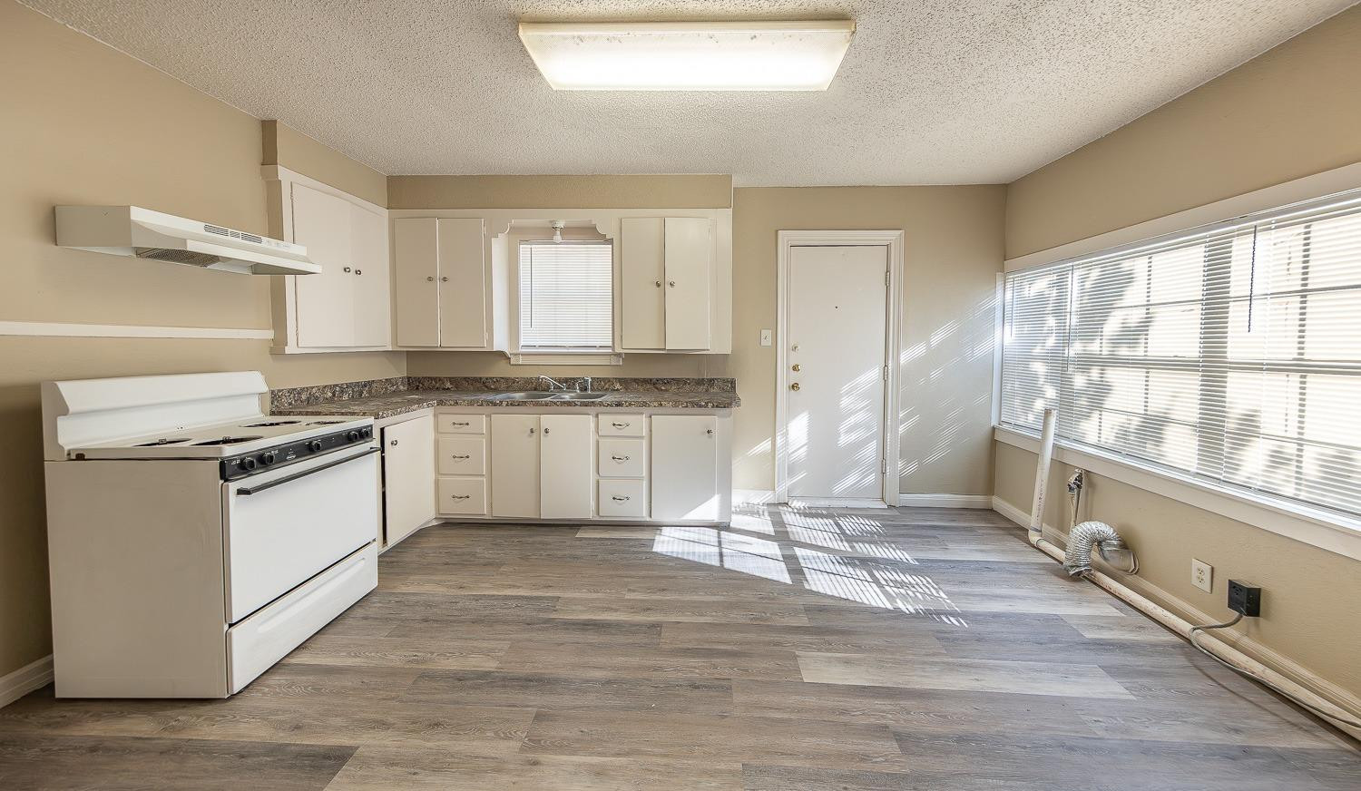2104 14th Street Lubbock, TX 79401 - Photo 3 of 17 a kitchen with granite countertop a stove top oven and cabinets