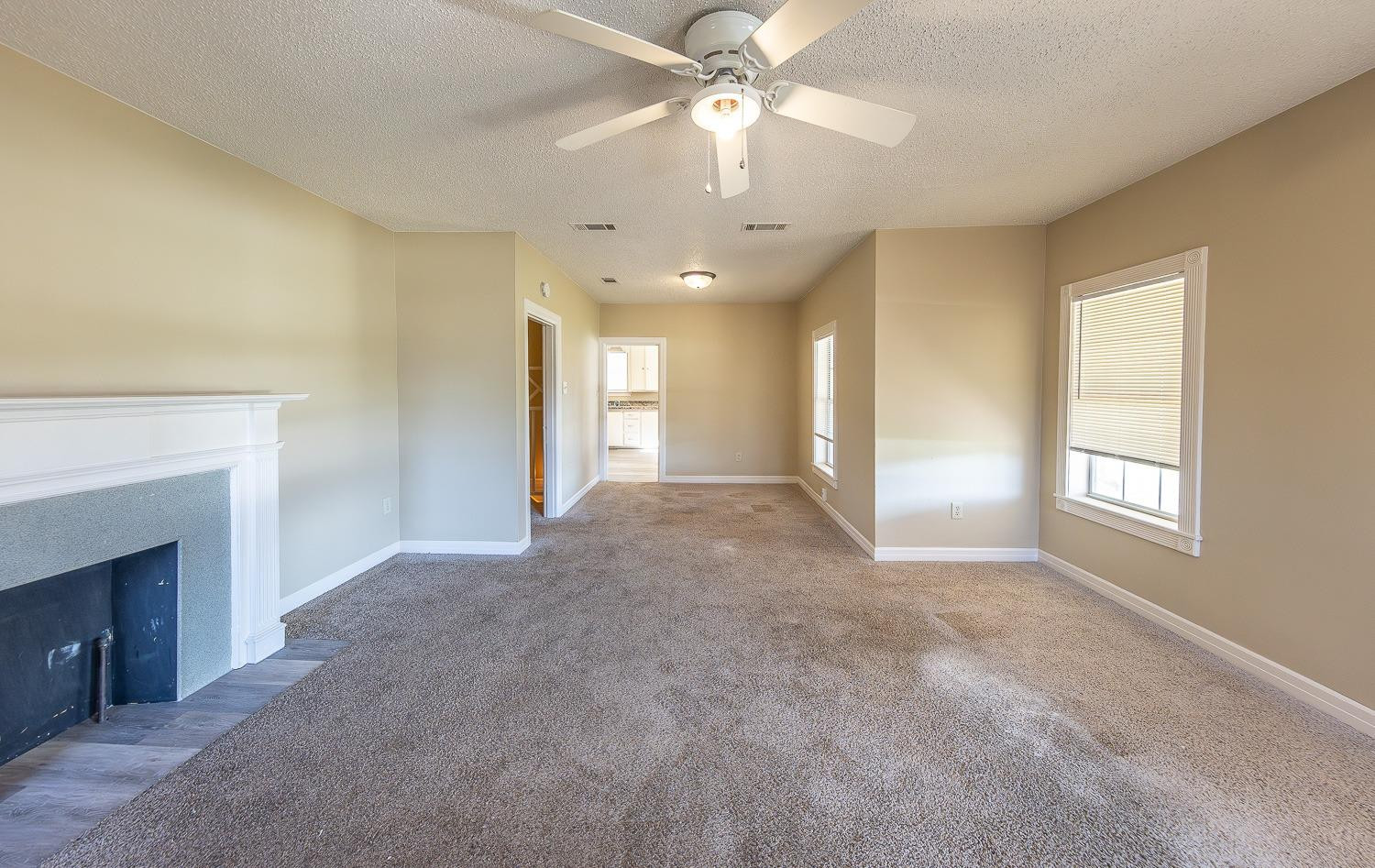 2104 14th Street Lubbock, TX 79401 - Photo 4 of 17 a view of a livingroom with a chandelier fan and a fireplace