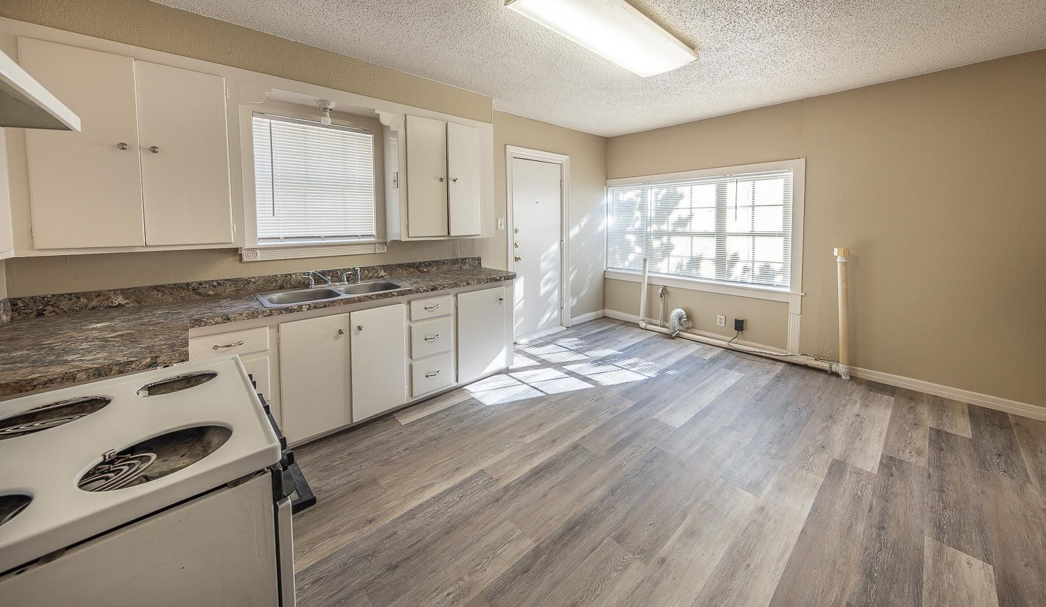 2104 14th Street Lubbock, TX 79401 - Photo 6 of 17 a view of a kitchen with wooden floor and electronic appliances