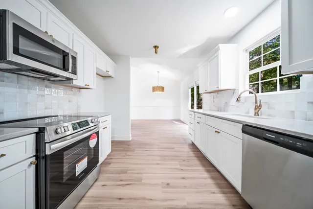 a kitchen with stainless steel appliances a stove a sink and a microwave