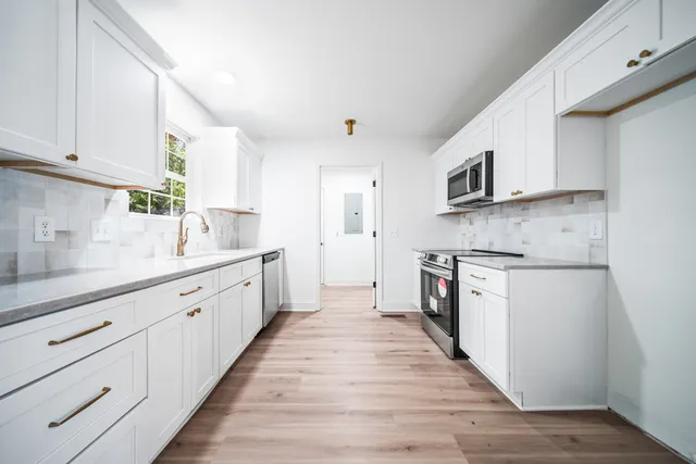 a large kitchen with stainless steel appliances granite countertop a stove and a sink