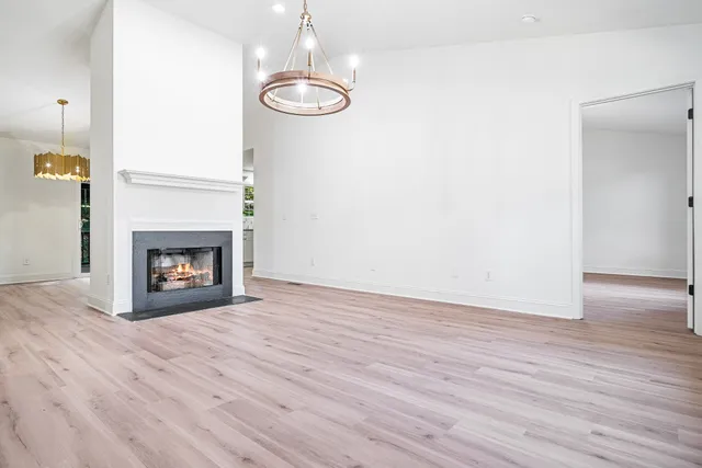 a view of empty room with wooden floor fireplace and window