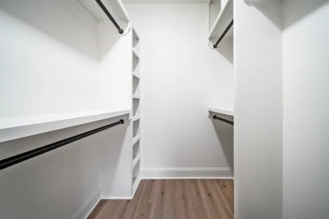 a view of walk in closet with wooden floor