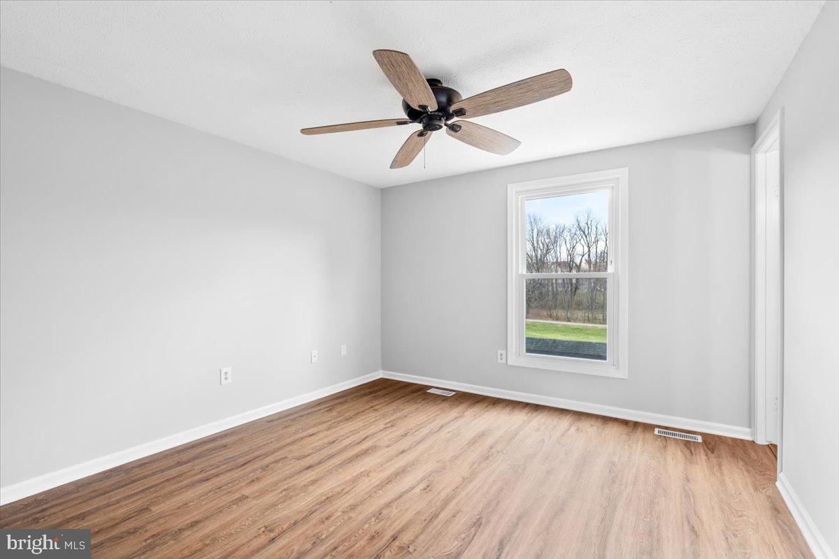 1489 Eden Drive Frederick, MD 21701 - Photo 17 of 43 an empty room with wooden floor fan and windows
