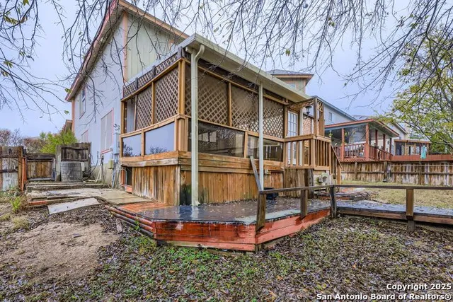 a view of a house with a yard and wooden fence