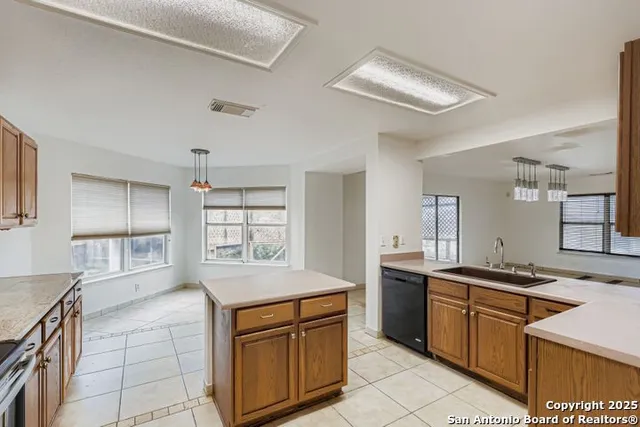 a kitchen with stainless steel appliances granite countertop a sink stove and cabinets