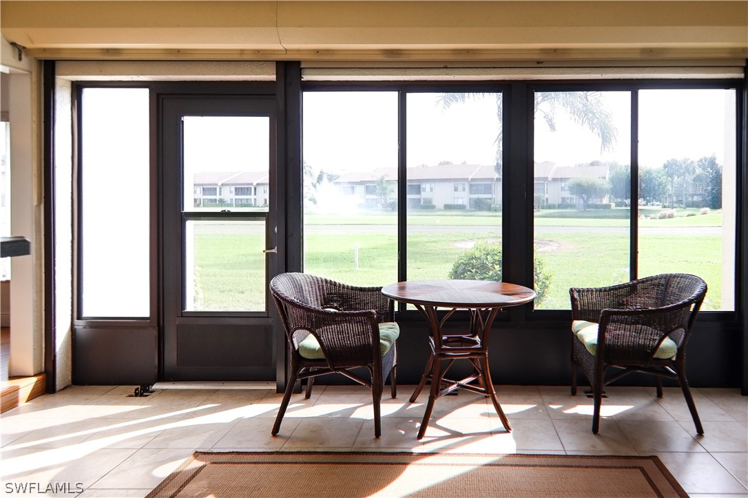 a dining room with furniture and floor to ceiling windows