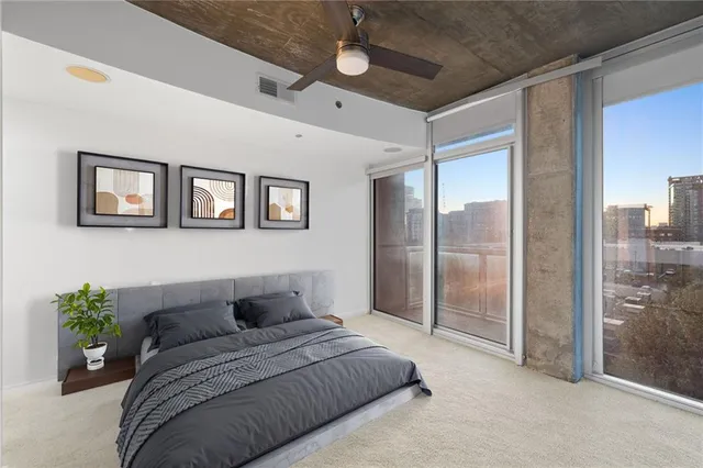 a bedroom with a balcony a bed and a glass door