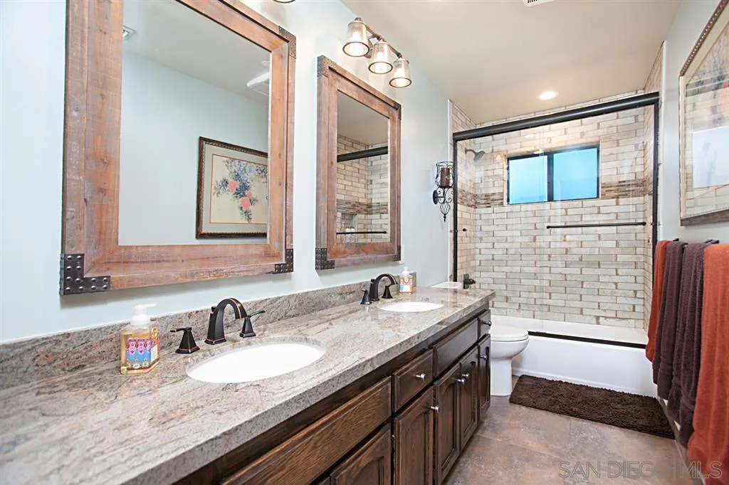 16987 Lyons Valley Road Jamul, CA 91935 - Photo 15 of 25 a bathroom with a granite countertop double vanity sink a mirror and a shower
