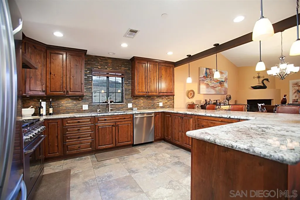 16987 Lyons Valley Road Jamul, CA 91935 - Photo 6 of 25 a large kitchen with kitchen island a sink stainless steel appliances and cabinets