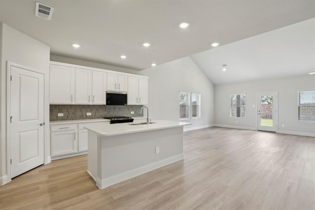 2206 Windy Trail Princeton, TX 75407 - Photo 2 of 34 a kitchen with a stove and a microwave