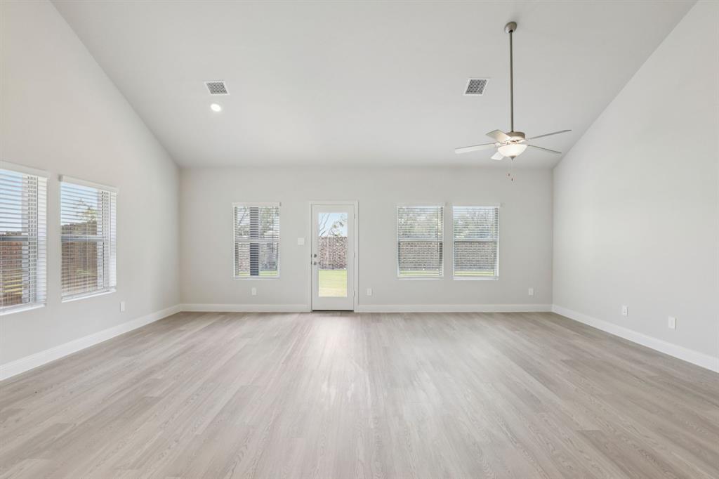 2206 Windy Trail Princeton, TX 75407 - Photo 8 of 34 a view of an empty room with a window and wooden floor