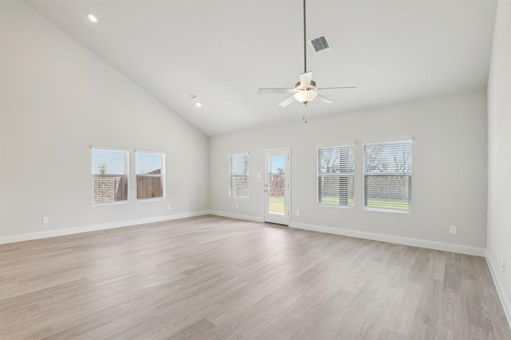 2206 Windy Trail Princeton, TX 75407 - Photo 9 of 34 an empty room with wooden floor chandelier and windows