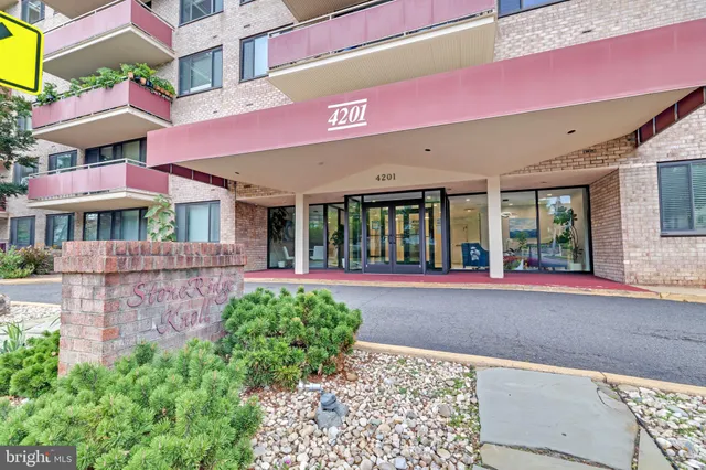 a front view of a building with a garden and plants