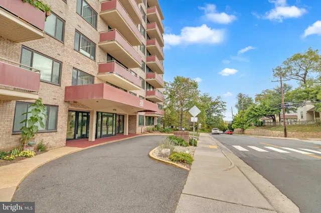 a front view of a building with a garden and plants