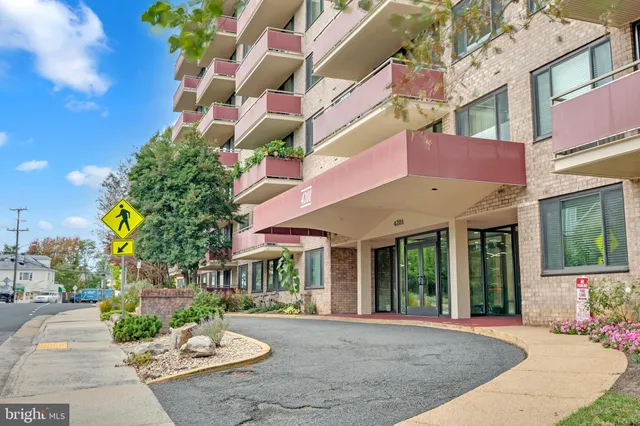 a front view of a building with a garden and plants