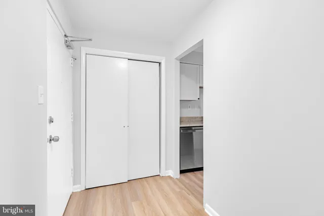 a view of an empty room with closet and a window