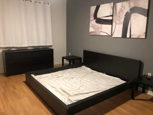 a bed sitting in a bedroom next to a window