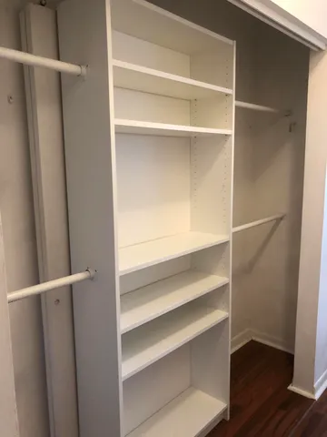 a view of walk in closet with empty racks